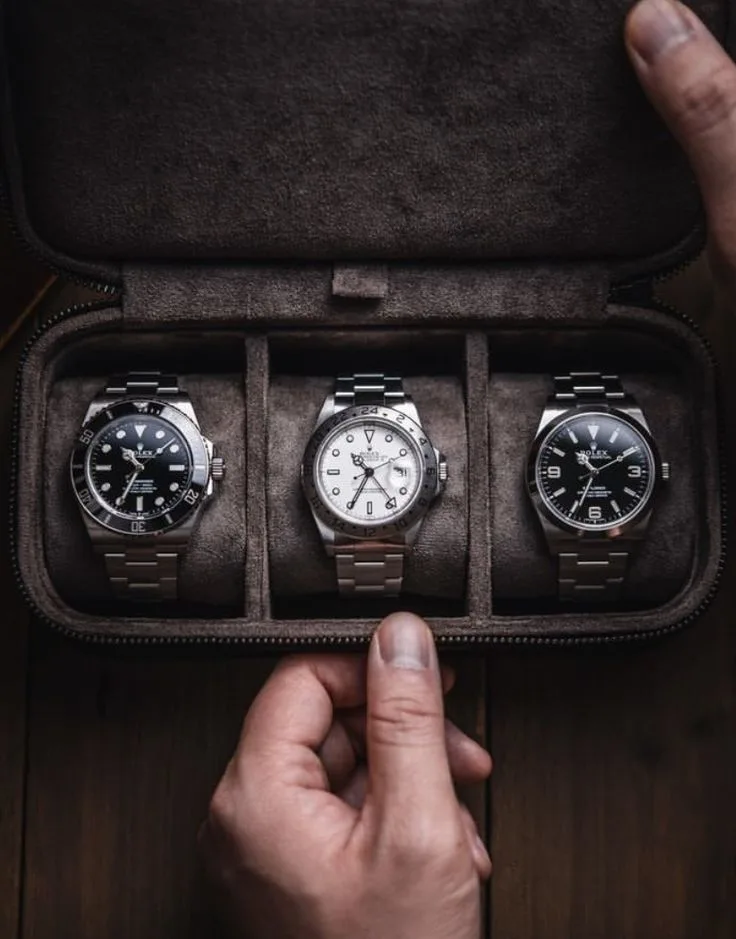 A curated three-watch Rolex collection in a suede-lined travel case, featuring a Rolex Submariner Date, a white dial Rolex Explorer II "Polar," and a Rolex Explorer 1 with a black 3-6-9 dial.