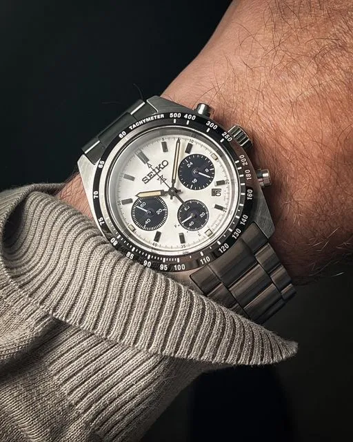
A wrist shot of a Seiko Prospex Speedtimer complication watch featuring a white panda dial, three black sub-dials, a black tachymeter bezel, and a stainless steel bracelet.