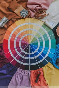 Circular color wheel chart with tint and shade gradients surrounded by matching fabric swatches and clothing materials for menswear coordination.